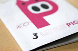 An informational booklet with a pink graphic resting on a tan surface.